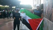 متظاهرة جزائري يرفع العلم الفلسطيني