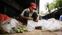 فقير يجمع طعاماً من القمامة بالهند (سوميابراتا روي/ Getty)