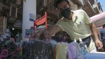 صاحب متجر يرتب أقنعة الوجه الطبية في أحد أسواق بغداد (فرانس برس)