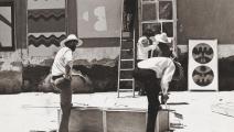 محمد المليحي أمام أحد أعماله في ميدان جامع الفنا بمراكش عام  1969 (من المعرض)