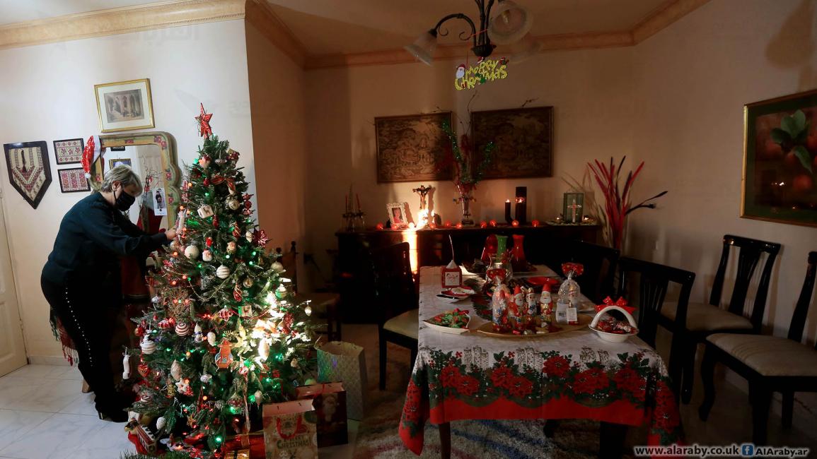 مسيحية فلسطينية تزين شجرة الميلاد بمنزلها في غزة (عبد الحكيم أبو رياش) 