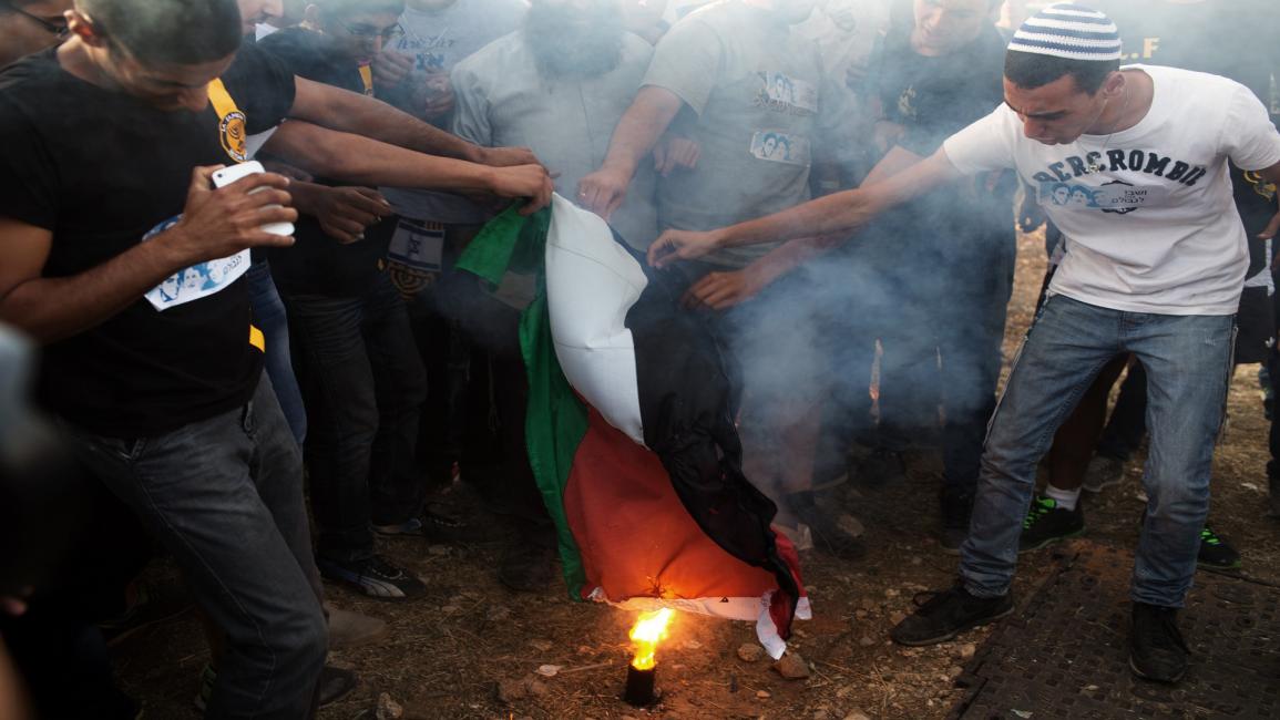 مستوطنون يحرقون العلم الفلسطيني