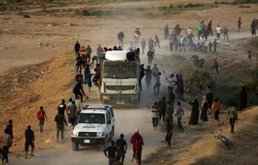 فلسطينيون يلاحقون شاحنة تحمل مساعدات وصلت عبر الرصيف البحري (مجدي فتحي/Getty)