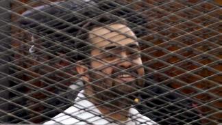 محمد عادل ناشط سياسي مصري في خلال محاكمة في مصر (الأناضول)