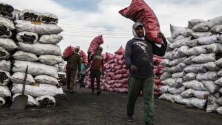 عمال مصريون يحملون أكياس فحم في 17 ديسمبر 2023 (Getty) 