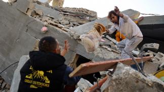 فلسطينيون يُخرجون خبزاً من أنقاض منزل دمره الاحتلال (سعيد خطيب/فرانس برس)