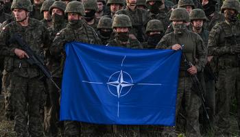 جنود بولنديون يحملون علم الناتو، 03 يوليو 2022 (Getty)