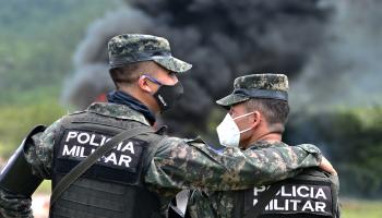 شرطيان يشاهدان حرق مخدرات في هندوراس (أورلاندو سييرا/ فرانس برس)