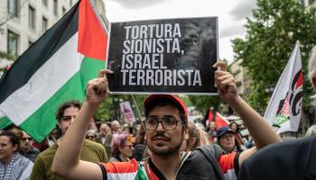 متظاهر يحمل لافتة كُتب عليها "التعذيب الصهيوني الإرهابي"، مدريد، 14 أيار/ مايو 2024 (Getty)