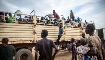 فارون من الحرب السودانية ينزلون من شاحنة