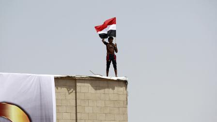 يلوّح بعلم اليمن في صنعاء خلال الاحتفال بذكرى الوحدة اليمنية، 2016 (محمد حويس/فرانس برس)