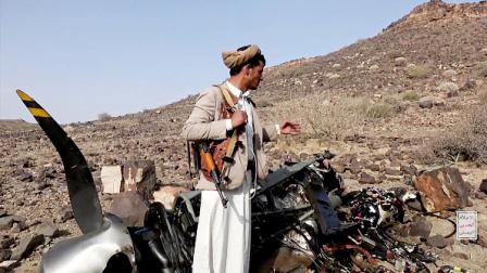 مقاتل من جماعة الحوثيين بجانب مسيّرة أميركية مدمرة (Getty)