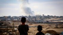 طفلان فلسطينيان يشاهدان الغارات الإسرائيلية على شرق رفح جنوبَي غزّة، 13 أيار/ مايو 2024 (Getty)