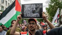 متظاهر يحمل لافتة كُتب عليها "التعذيب الصهيوني الإرهابي"، مدريد، 14 أيار/ مايو 2024 (Getty)
